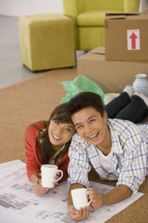 Asian couple with blueprints in new house