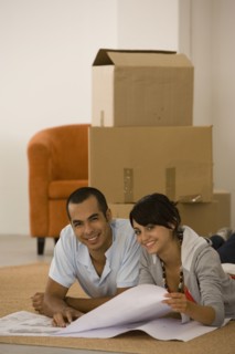 Young couple looking at blueprints in new house