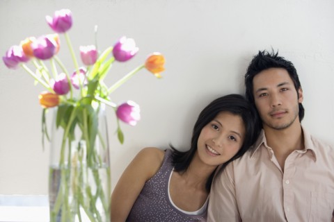 Asian couple next to flowers in vase