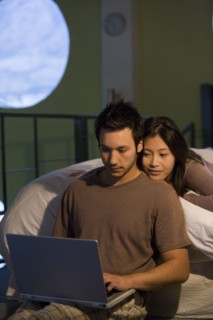Asian couple looking at laptop
