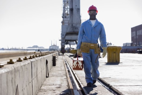 African American male construction worker carrying toolbox
