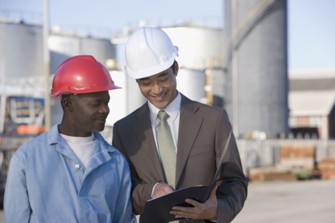 Multi-ethnic businessman and construction worker looking at paperwork