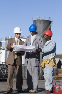 Multi-ethnic businessman and construction workers looking at blueprints