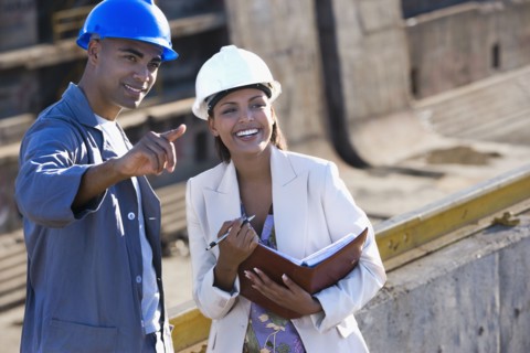 African American businesswoman and construction worker pointing