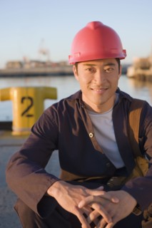 Asian male manual worker wearing hardhat