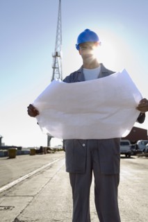 African American construction worker holding blueprints