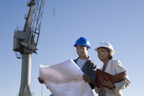 African American businesswoman and construction worker with blueprints