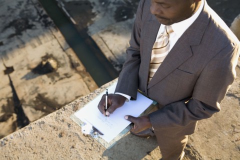 African American businessman writing on clipboard