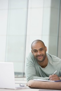 African man writing on notepad