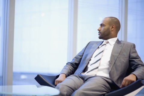 African businessman looking out window