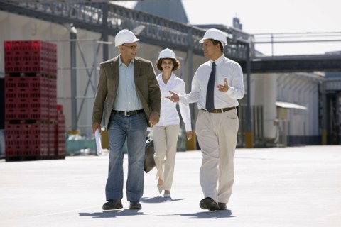Business people walking outside factory