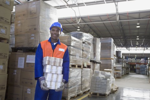 African worker carrying package in warehouse