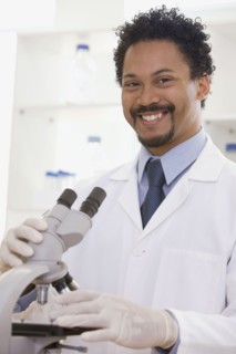 African scientist performing analysis in laboratory with microscope