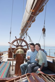 Caucasian couple toasting each other on sailboat