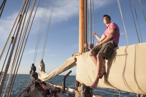 Caucasian man relaxing on sailboat