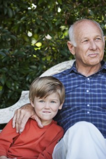 Caucasian boy sitting with grandfather on bench
