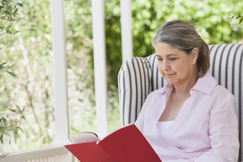Senior Caucasian woman reading on porch