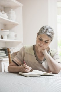 Caucasian woman writing in journal