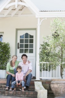 Caucasian family smiling on front steps