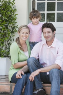 Caucasian family smiling on front steps