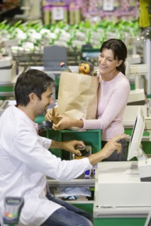 Caucasian woman talking to clerk in grocery store