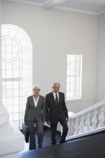 Senior Caucasian business people climbing office steps