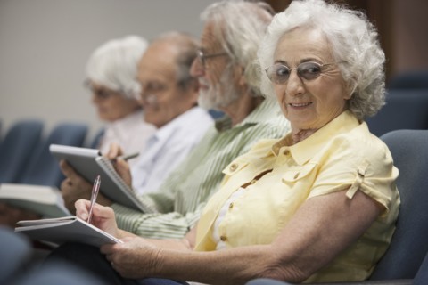 Senior Caucasian students taking notes in classroom