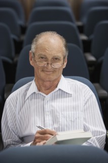 Senior Caucasian student taking notes in classroom