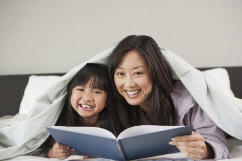 Mother and daughter reading in bed