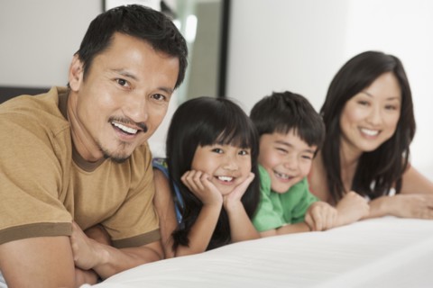 Family laying together on bed