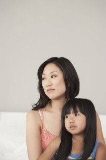 Mother and daughter sitting on bed