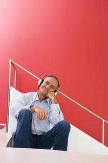 Man listening to headphones on stairs