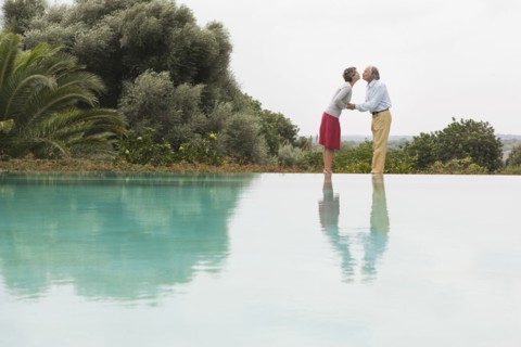 Couple kissing by infinity pool
