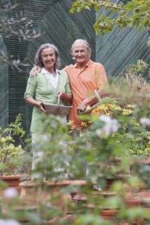 Couple tending plants in greenhouse