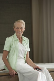 Senior Caucasian woman sitting on bed
