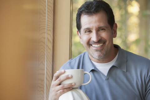 Hispanic man having cup of coffee