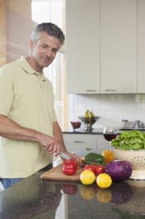 Hispanic man chopping vegetables in kitchen