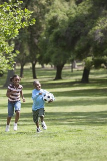 African American children playing soccer in park