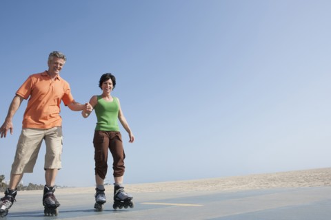 Caucasian couple rollerblading by beach