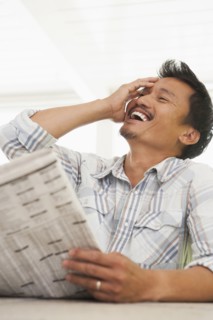 Asian man reading newspaper