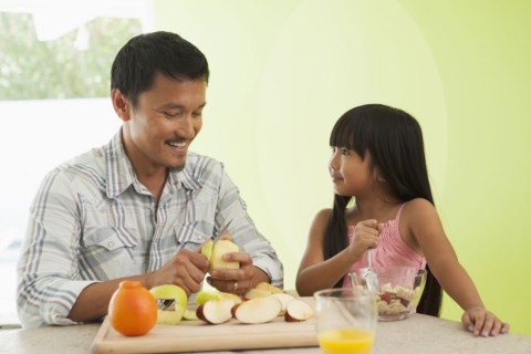 Asian father and daughter having breakfast together