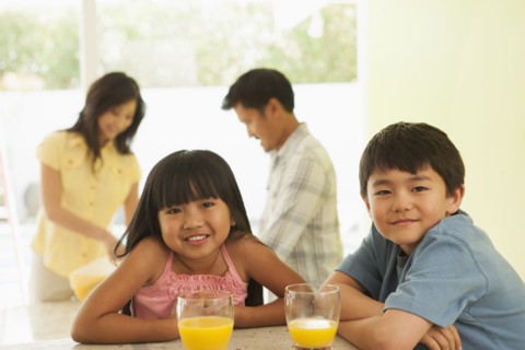 Children drinking orange juice at breakfast