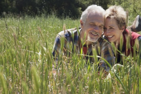 Senior Caucasian couple laying in tall grass