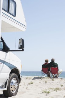 Senior Caucasian couple in lawn chairs overlooking ocean