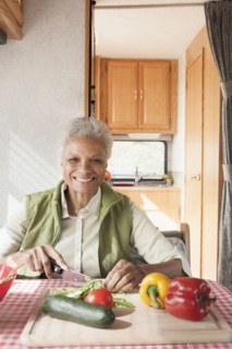 Mixed race Senior woman cooking in RV