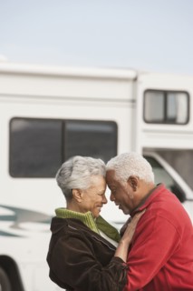 Mixed race Senior couple hugging by RV