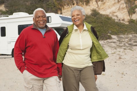 Mixed race Senior couple walking on beach
