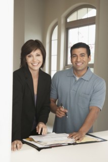 Realtor and client signing papers in new home