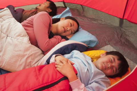 Asian family sleeping in tent