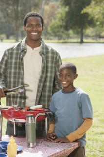 Father and son cooking at picnic table